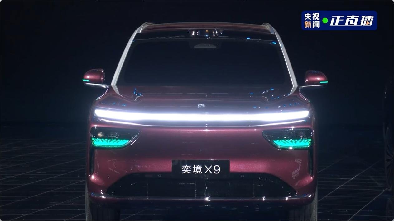 Yijing X9 SUV in dark red with Huawei Qiankun branding backdrop showing green LiDAR light strips