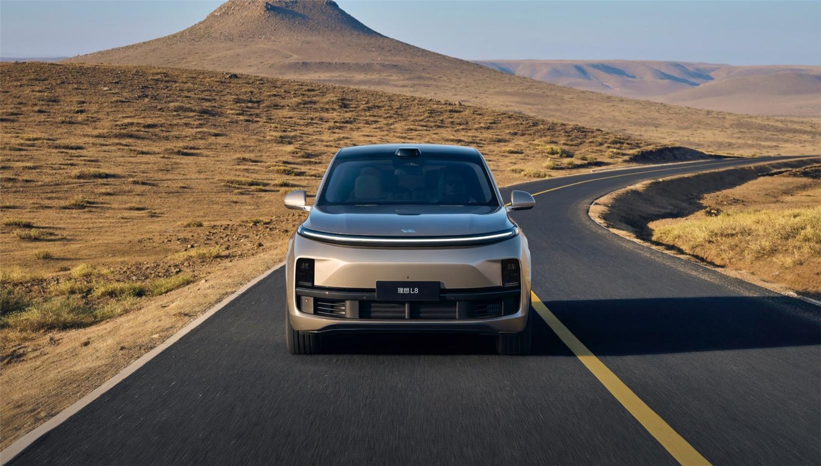 Li Auto L8 silver full-size SUV driving on desert highway with black roof and full-width DRL light bar