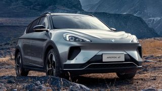Silver ARCFOX Alpha T7 mid-large SUV on rocky terrain against layered blue-grey mountain ranges